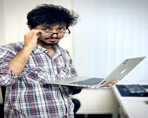 Office worker looking away from laptop screen
